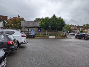 Cars parked at the Ashford Borough Council car park on Station Road, Tenterden, with a pay-here machine and council sign